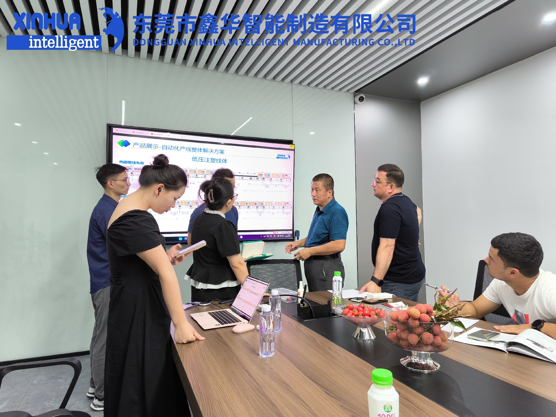 三位蒙古客戶在會議室聽取外貿業務員小劉的講解